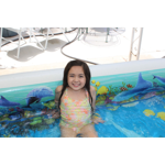 a little girl sitting in a swimming pool